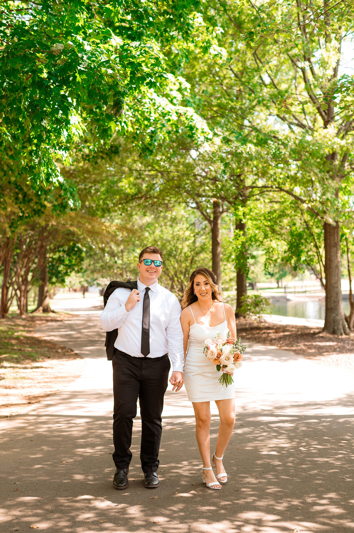 Couple holding hands smiling at camera after ceremony