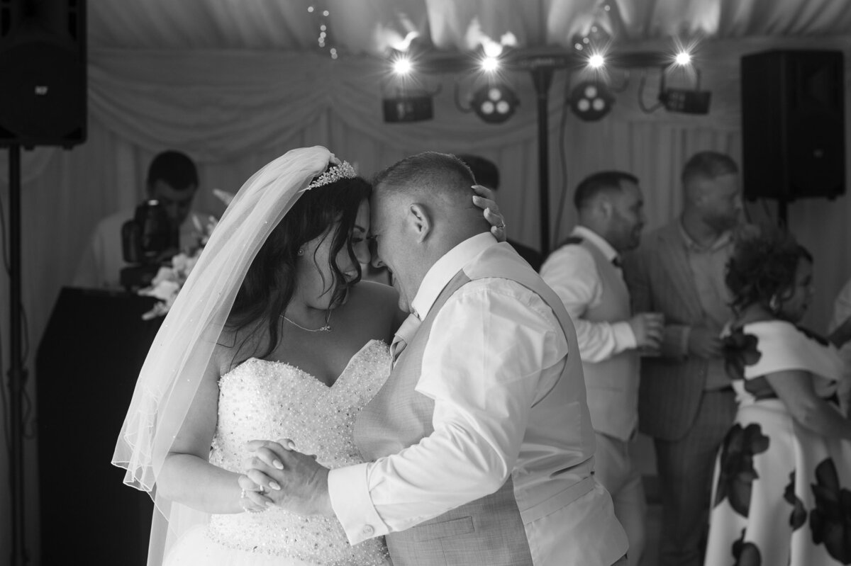 Bride and groom dancing with laughter at evening reception – candid Manchester wedding photo.