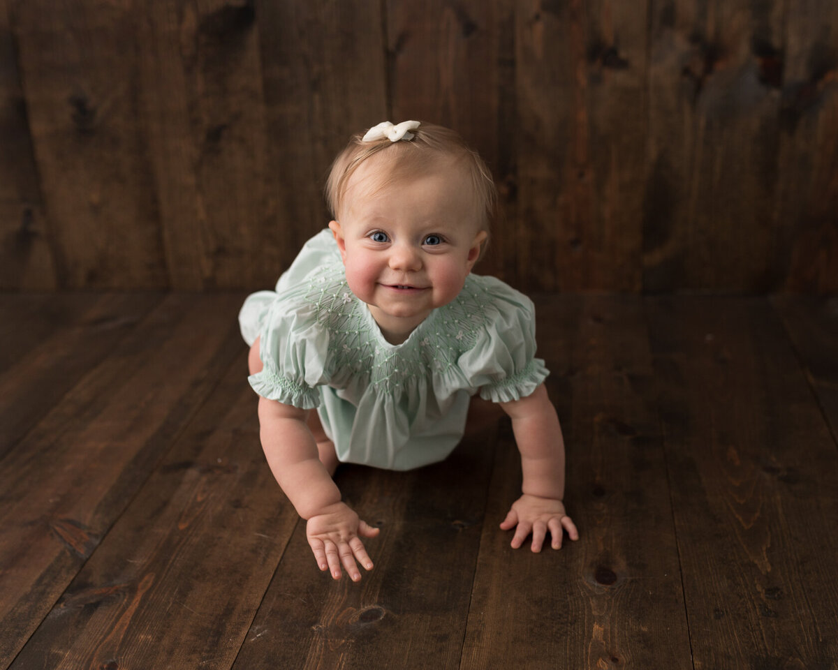 Crawling baby portrait in green dress