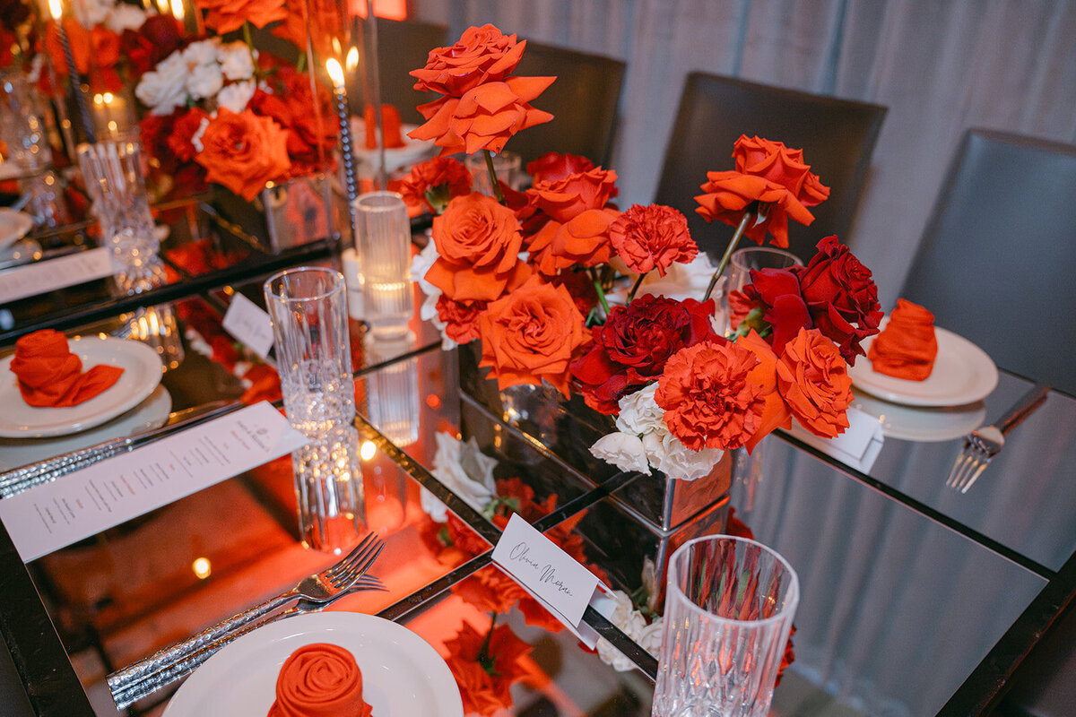Vibrant red florals layered with candlelight and mirrors at an editorial-style San Antonio wedding