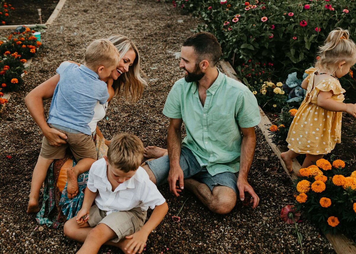 A Pittsburgh family photographer captures the joyful moments of a family playing in a flower garden with their children.