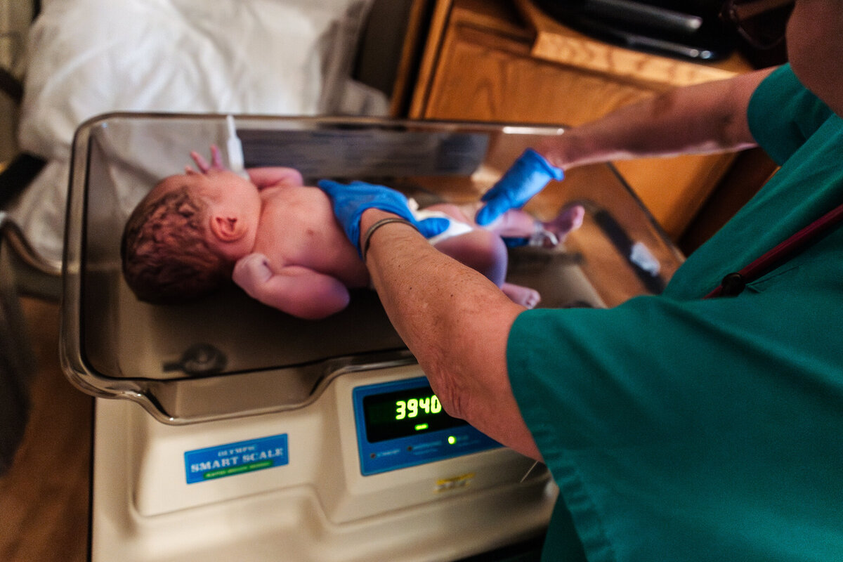 A baby is weighed for the first time.  Baby was born at Memorial hospital in Modesto. Shayna cox was the doula. 