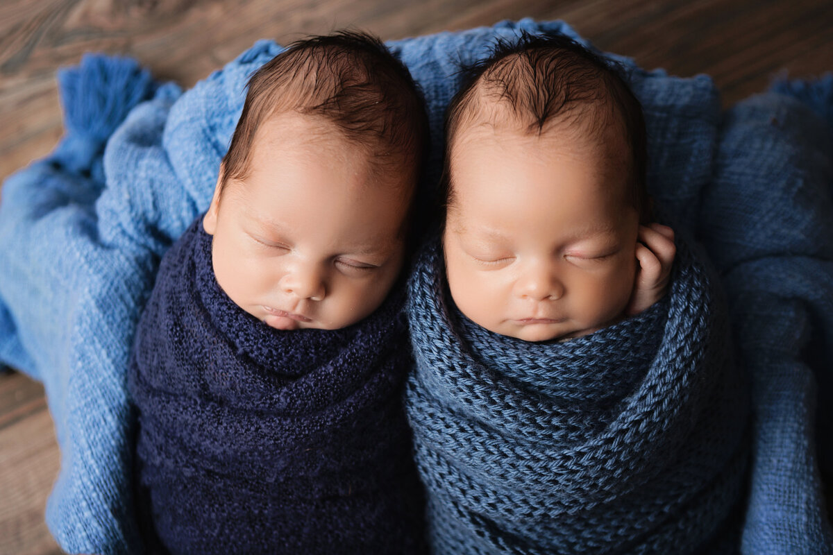 newborn twin boys wrapped in blue