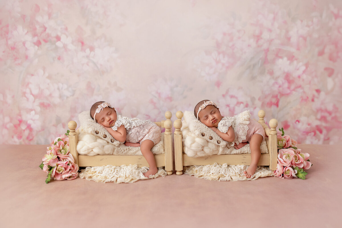 Newborn twins in beds surrounded by cherry blossom florals