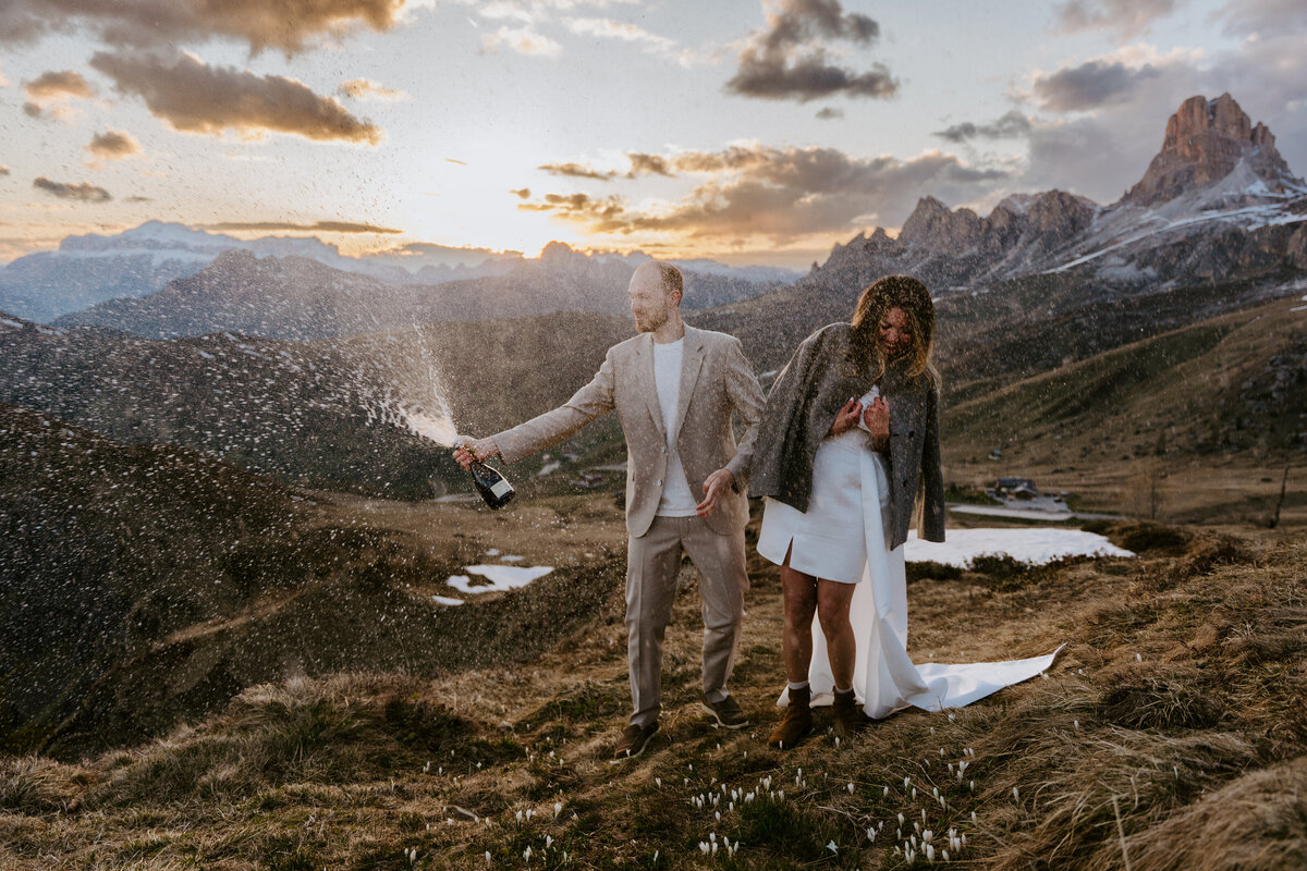 romantic couple drinking wine during twilight elopement in Dolomites