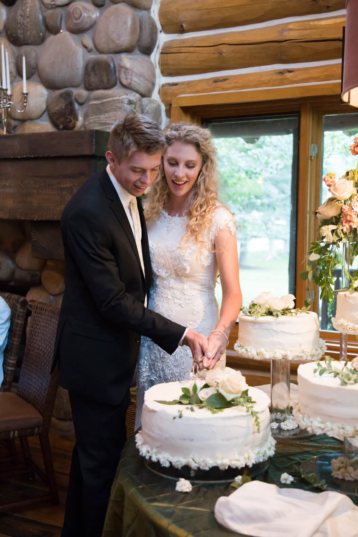 bride and groom cutting cake in a cabin at their mountain wedding