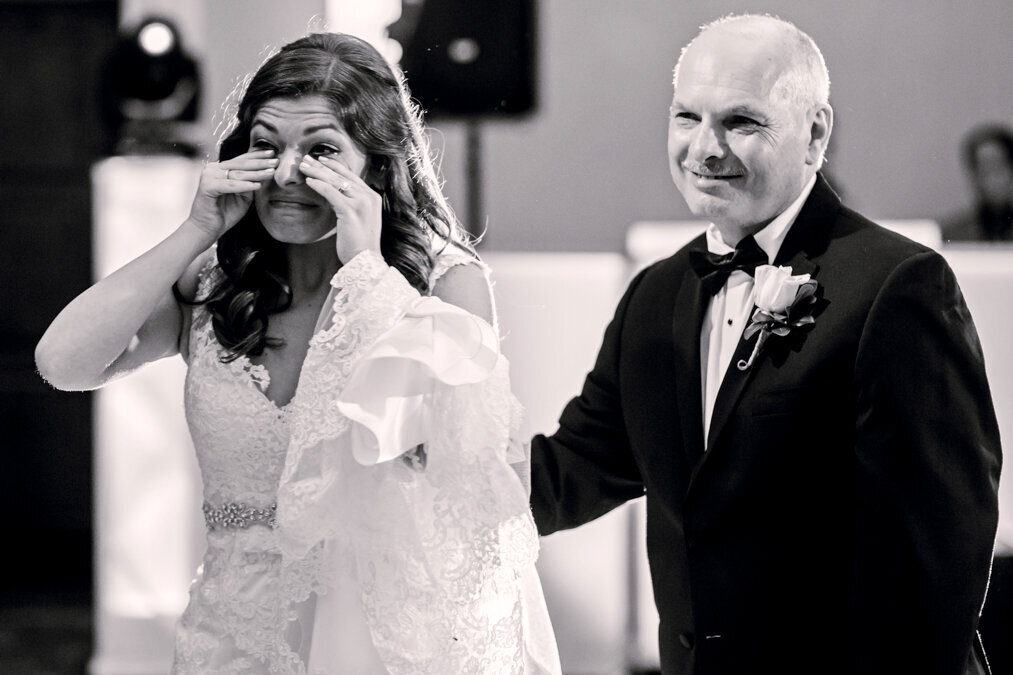 A bride walks down the aisle with her father.