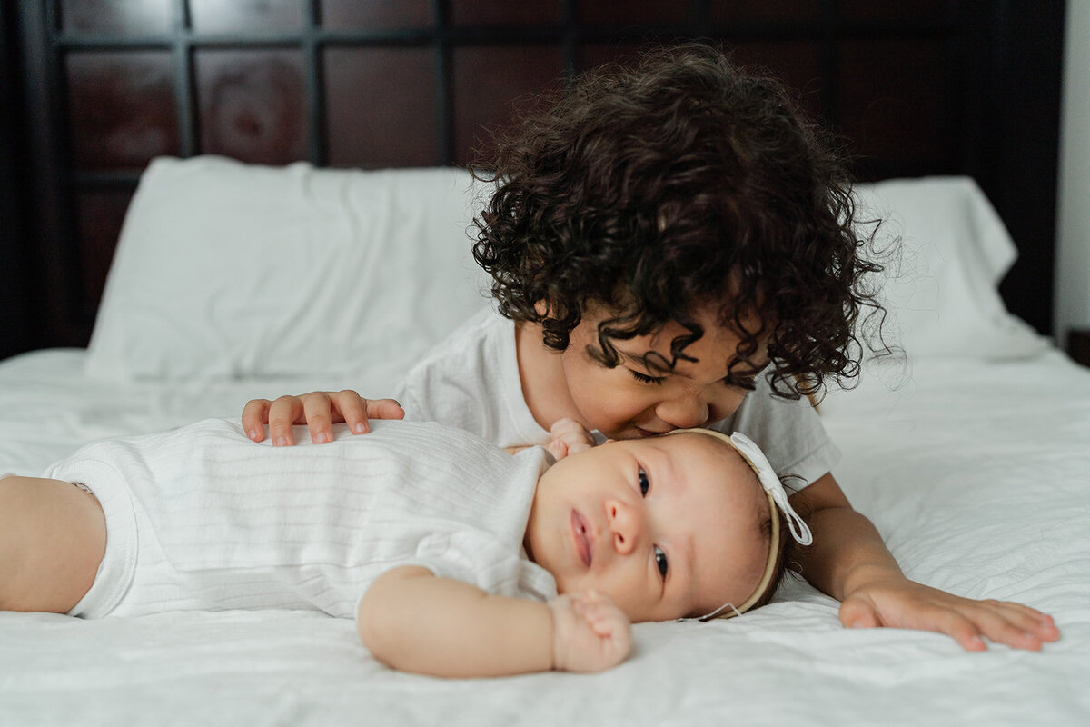 older-sibling-kissing-newborn-bonding