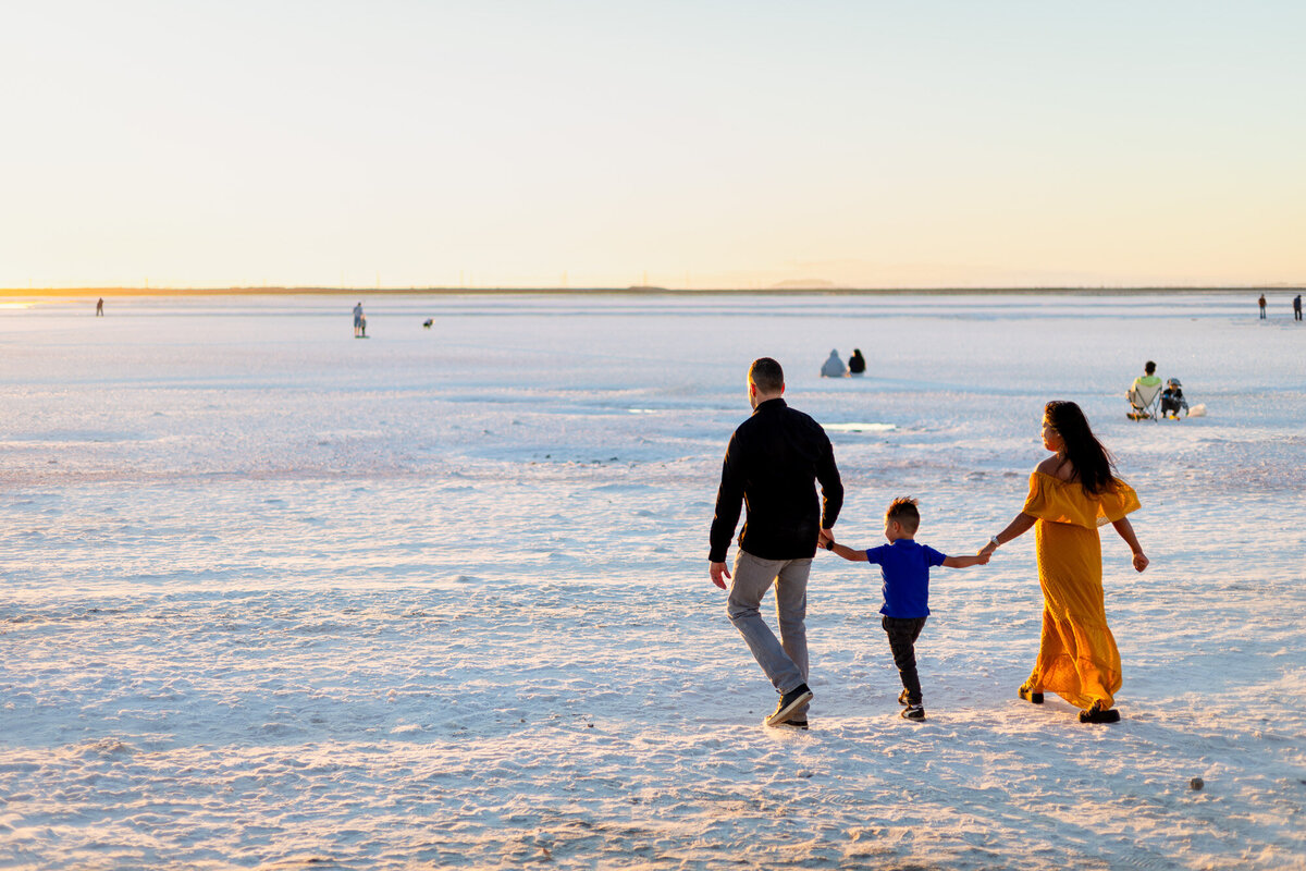 Family walking together across sunlit salt flats, hand-in-hand – Bay Area Family Portfolio - Ellobelle Photography