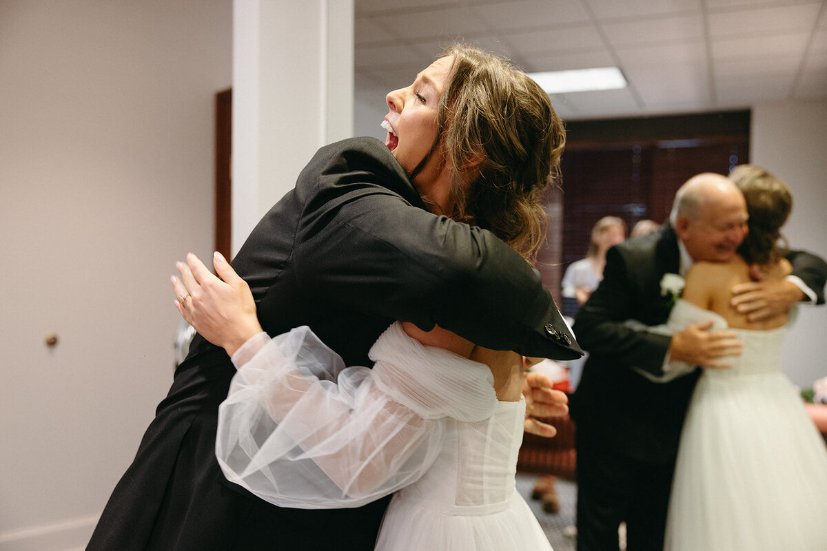 Bride is greeted with a hug by her father on her wedding day during the father/daughter first look. 