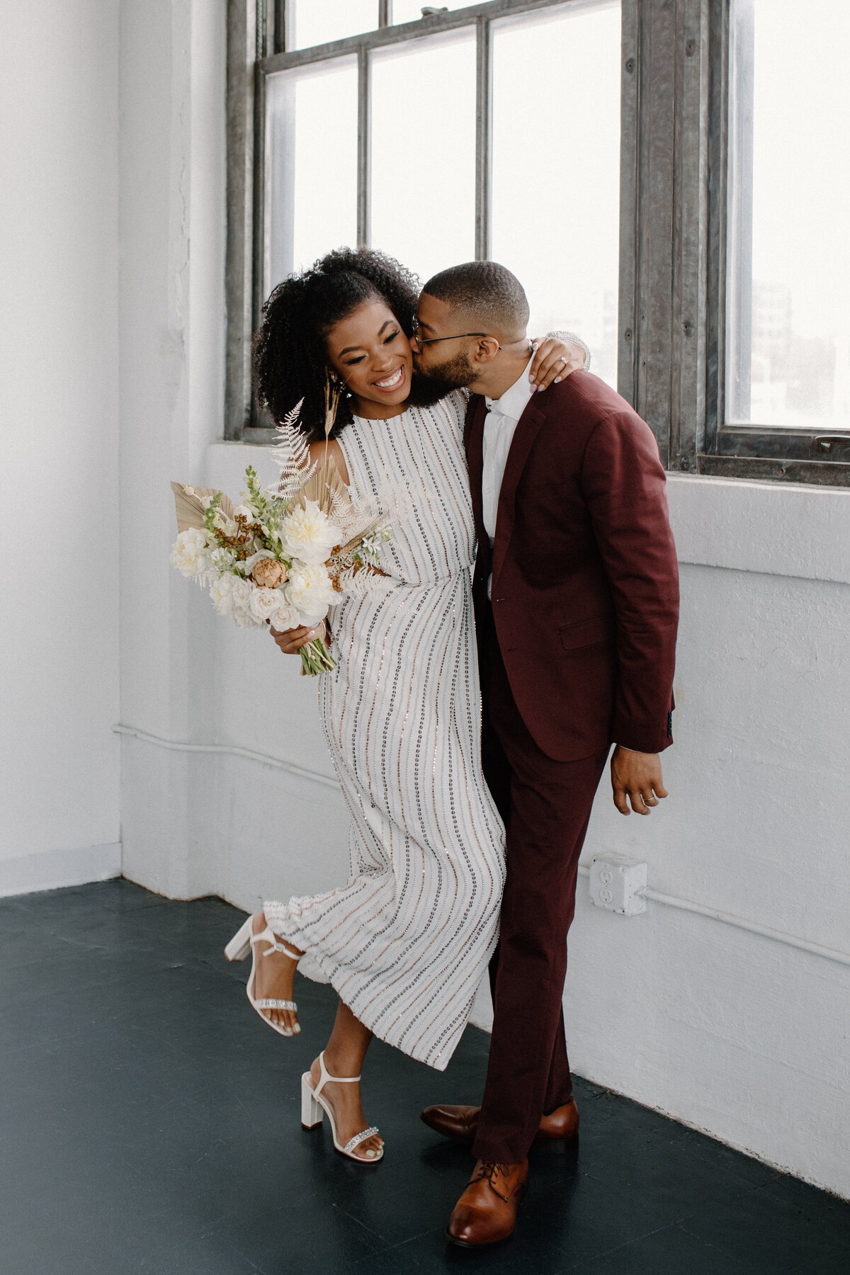 wedding couple kissing by window