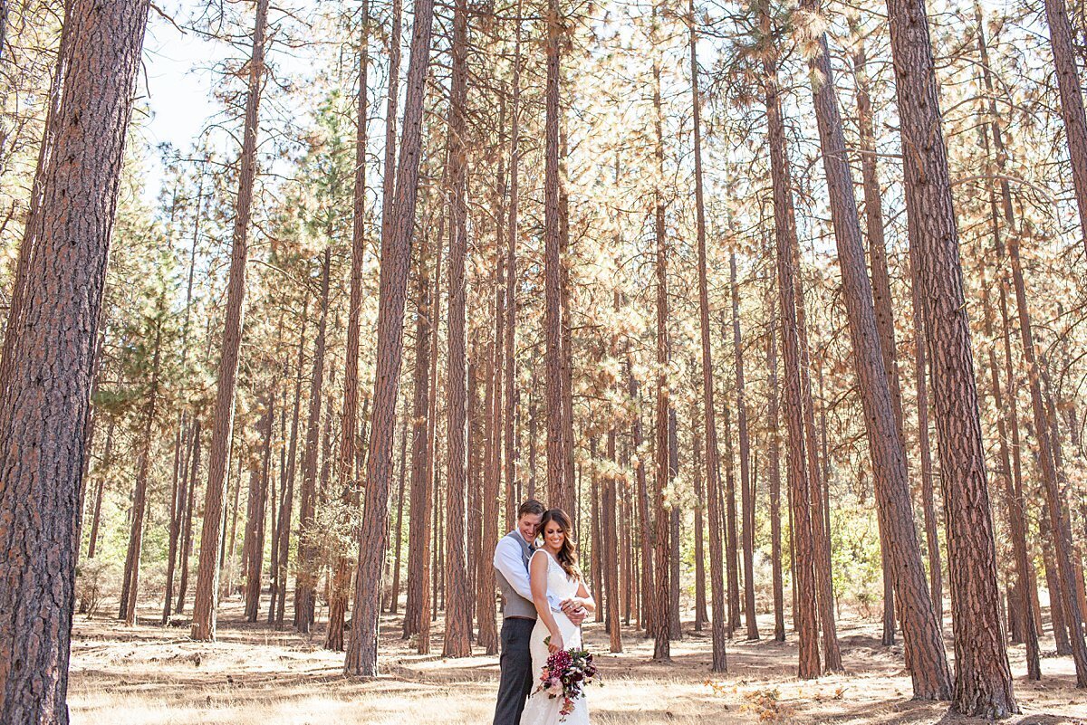 Bride and groom in the woods with tall trees