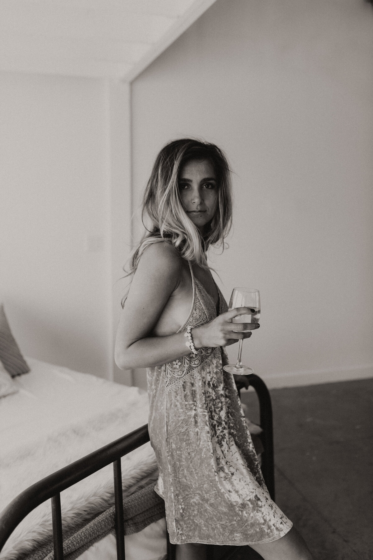 woman drinking in boudoir bed session black and white