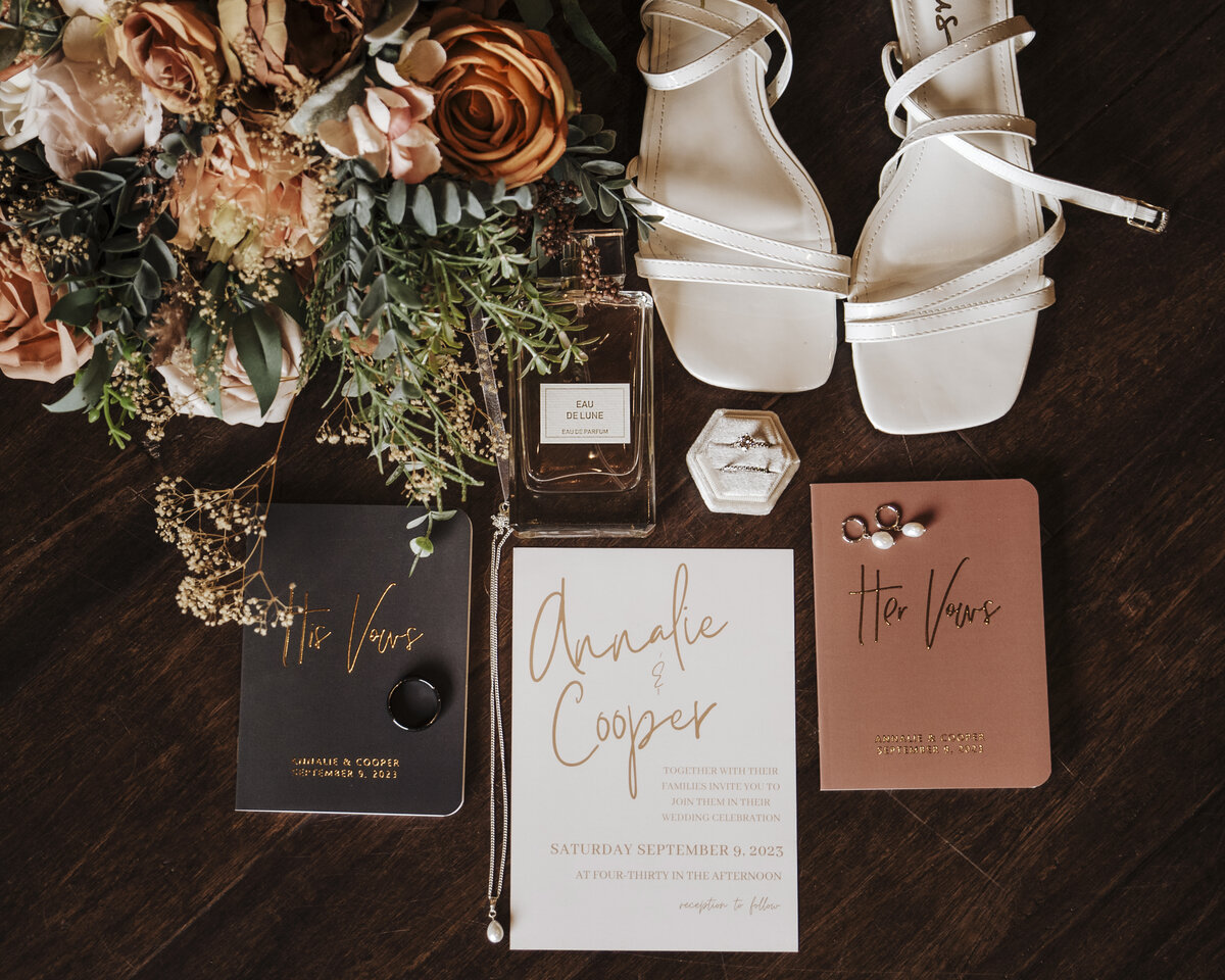 Elegant wedding flat lay featuring bridal accessories, a lush bouquet, sophisticated invitations, and a hint of floral romance taken by jen Jarmuzek photography a Minneapolis wedding photographer