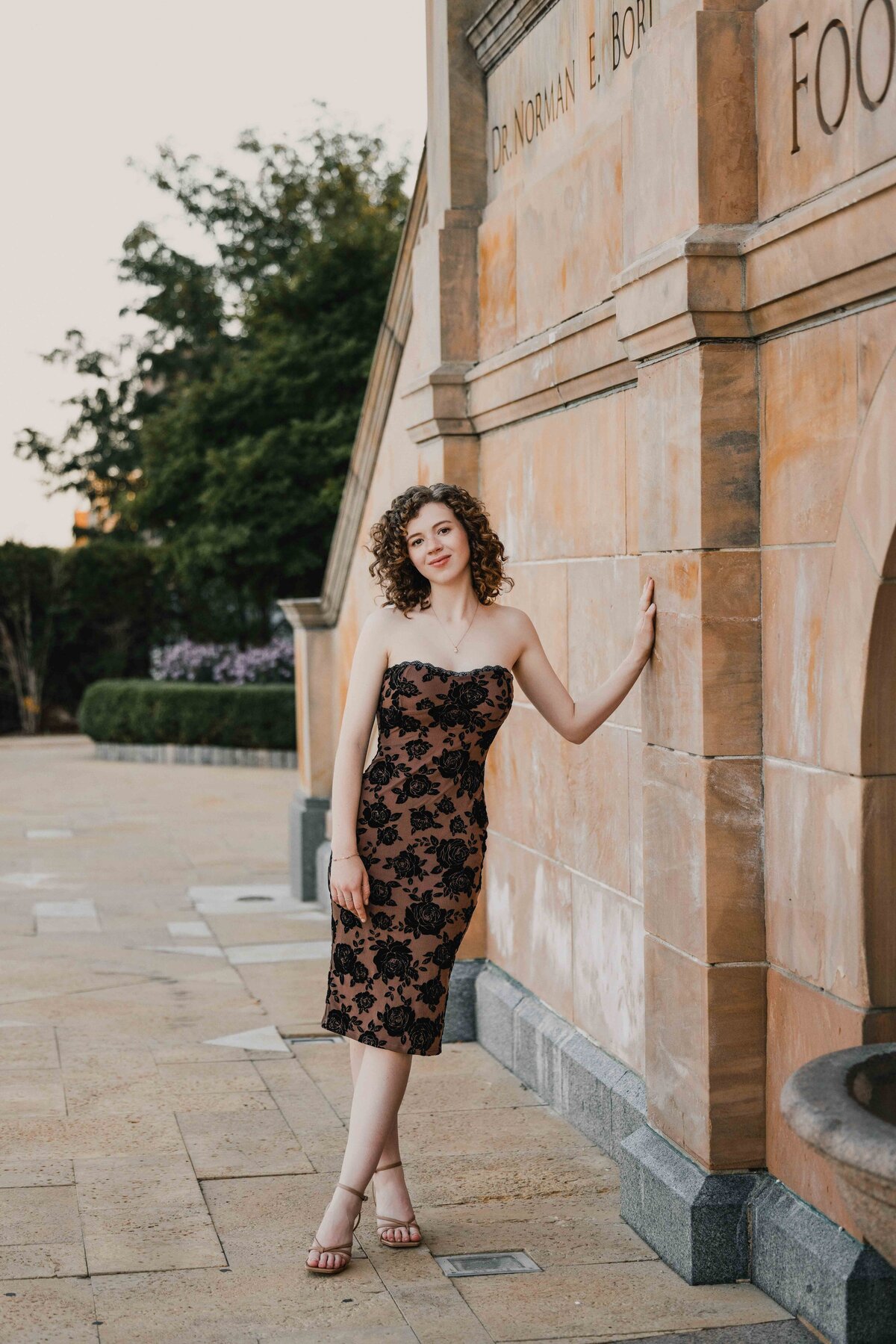 Outdoor senior portrait at a historic stone building, capturing sophistication and grace.