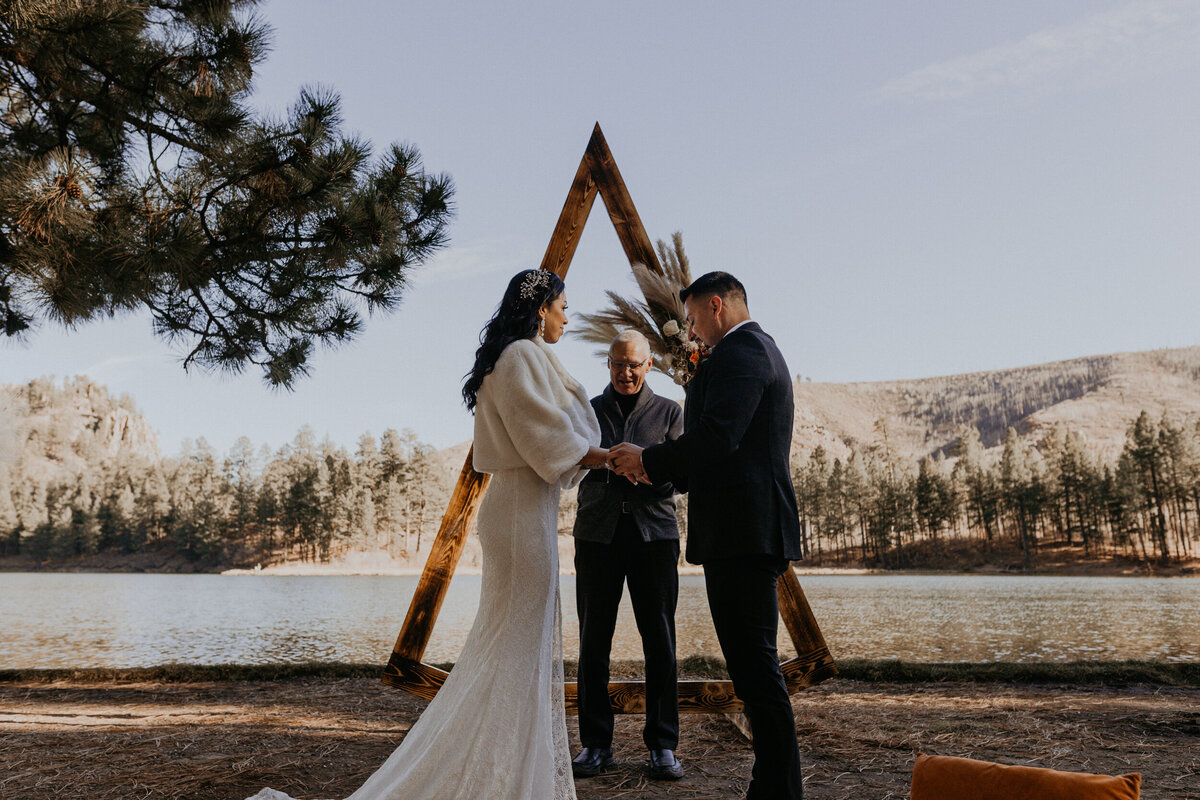 bride and groom having their elopement ceremony in front of a lake in New Mexico