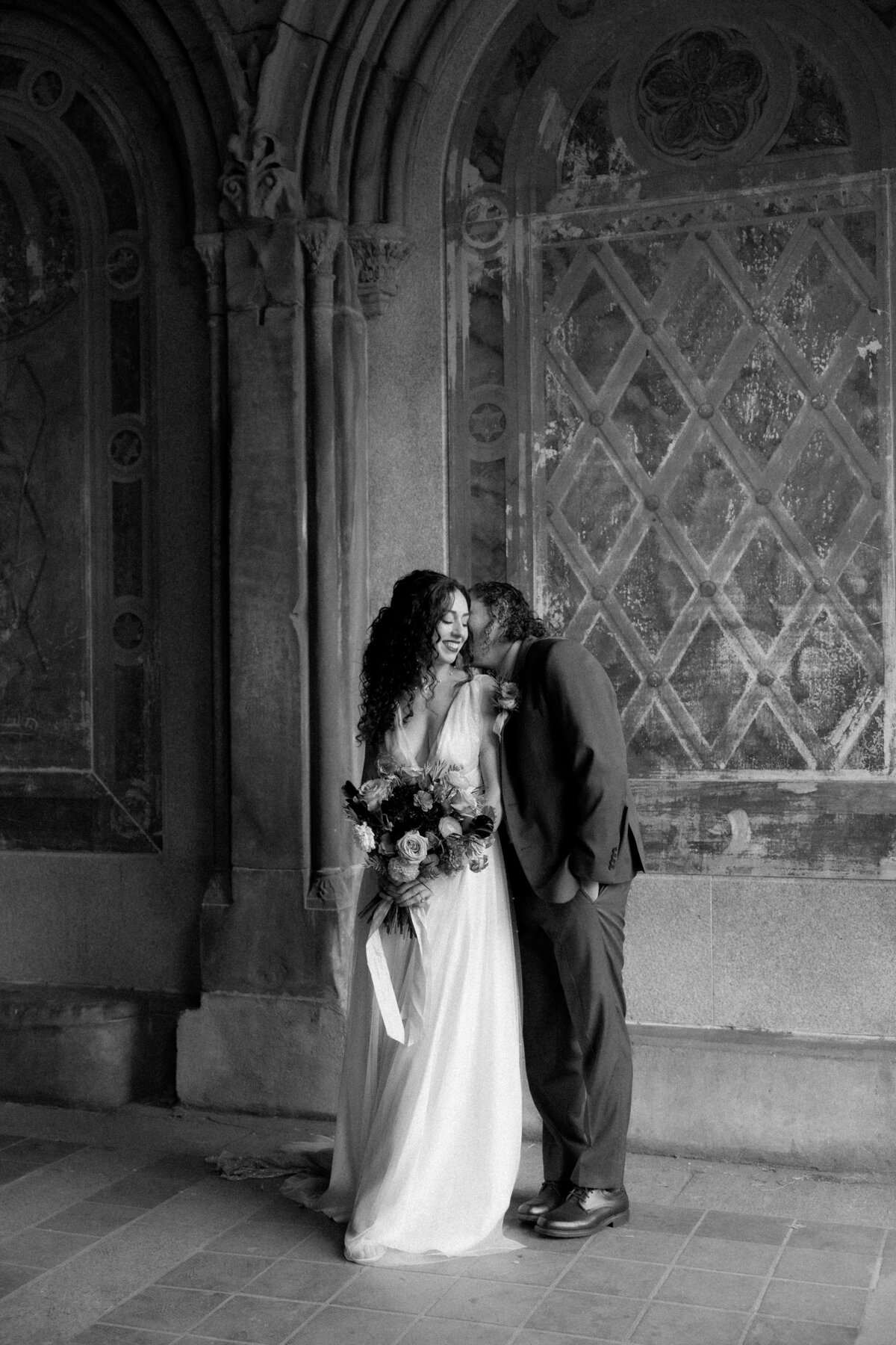 The couple sharing a tender moment beneath Central Park’s beautiful stone arches.