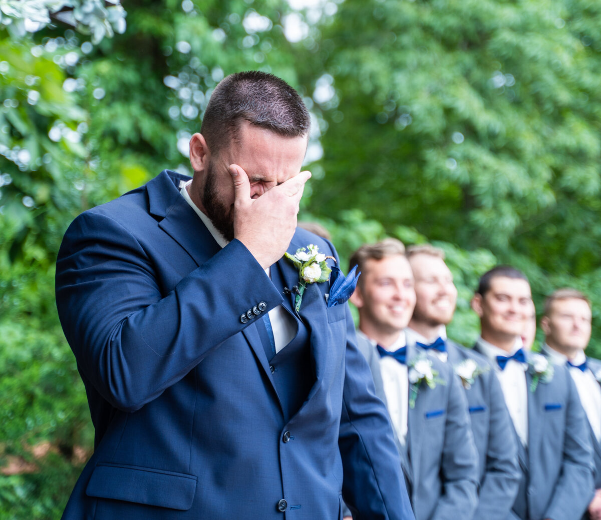 The groom, Ryan Bee, wiping away his tears after seeing his beautiful bride, Mahalie, walking down the aisle at their wedding at The Old Blue Rooster Event Center LLC in Lithopolis, Ohio.