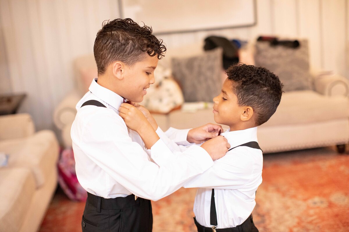 two boys straighten each other's ties at Milestone New Braunfels wedding