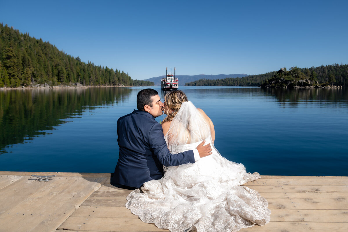 Bride and Groom eloping and kissing at South Lake Tahoe Emerald Bay boat dock at Vikingsholm Trail during sunset.