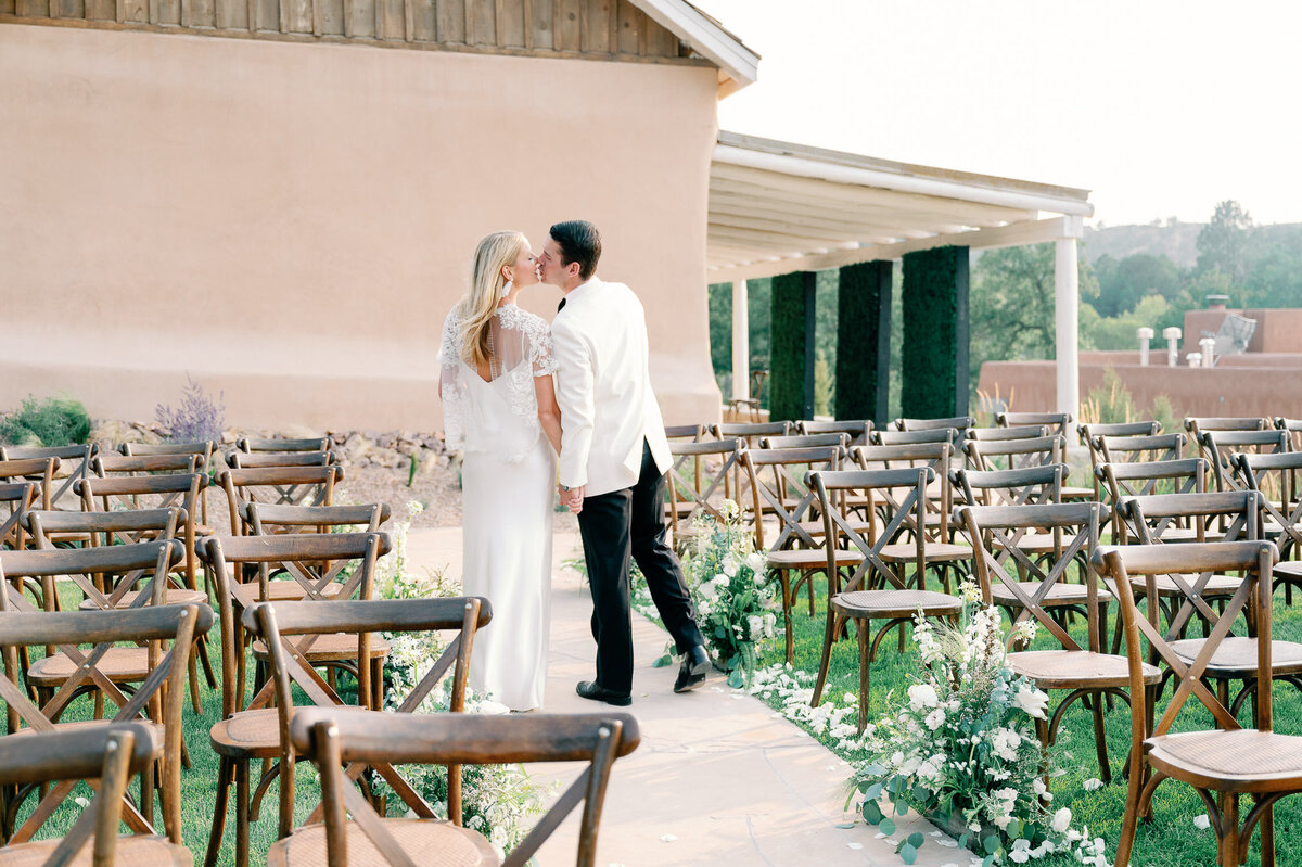 Bride and groom kiss at wedding ceremony site at Bishops Lodge in Santa Fe