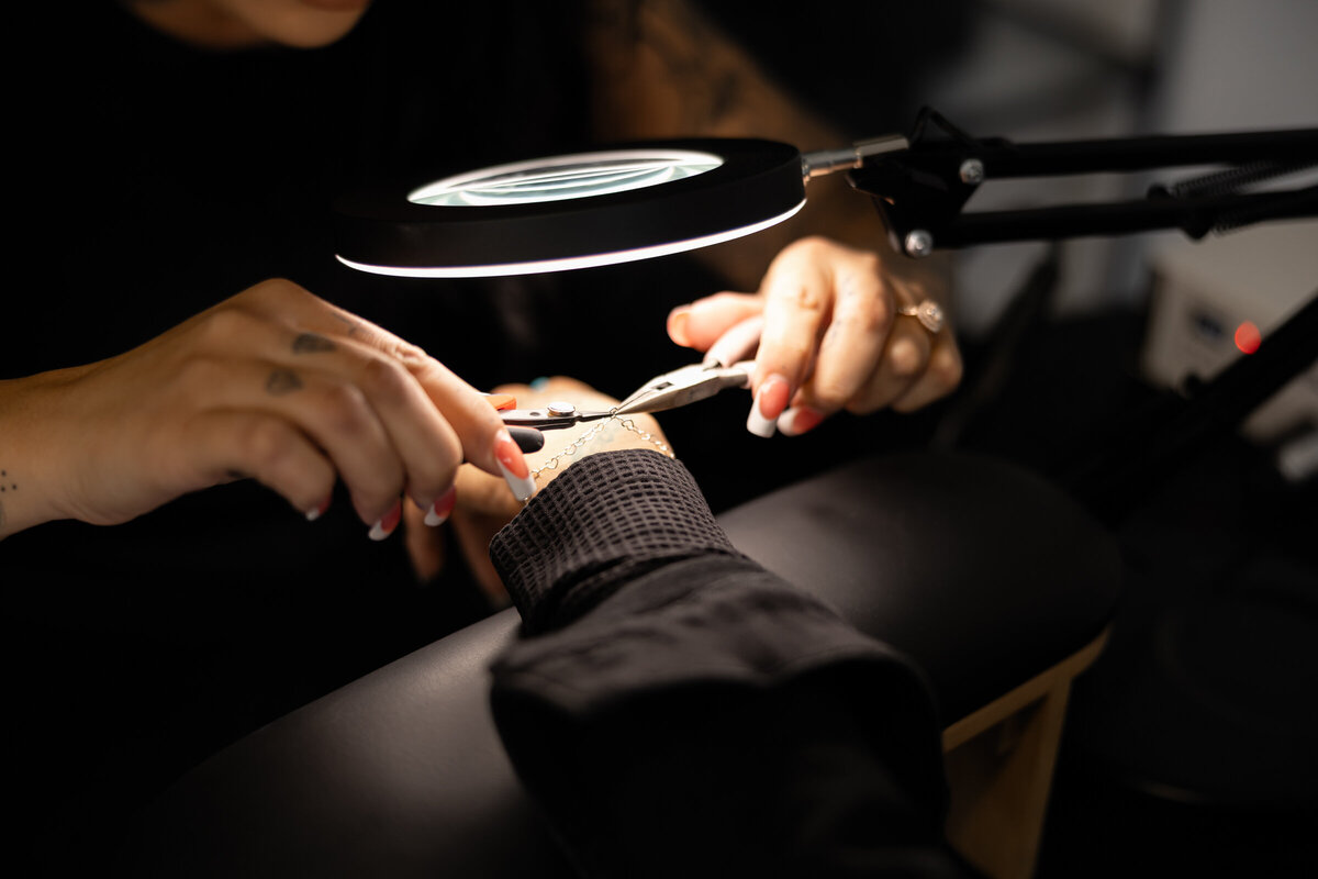 Makeup artist working on client’s brows under salon lighting. Photograph by Yucaipa branding photographer Kaitlyn Dawn Photography.