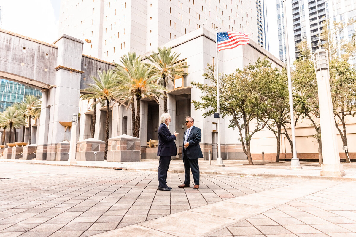 two men talking in front of court house