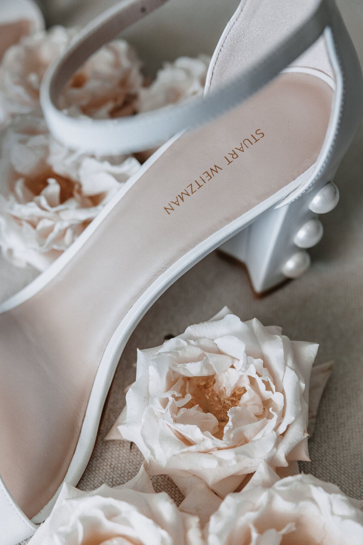 close up of Stuart Weitzman heel with pearls surrounded by pink florals