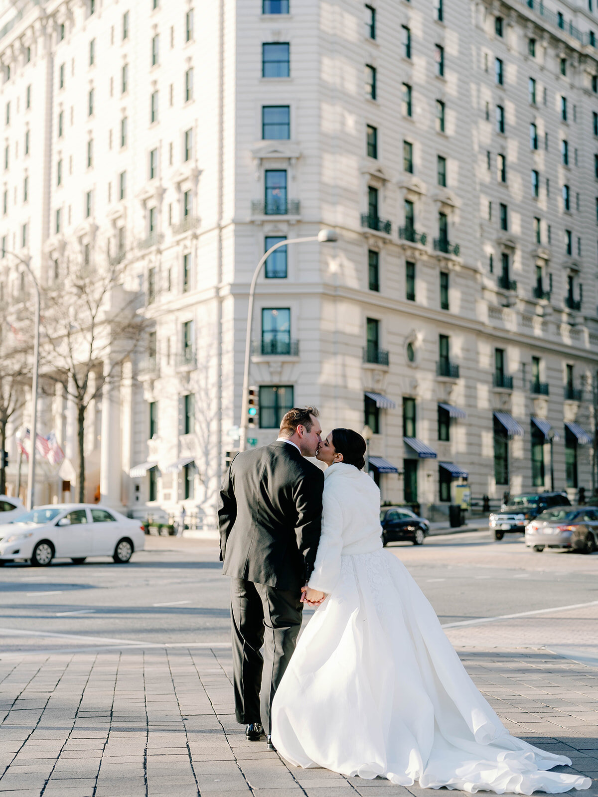 Bride and groom stroll outside of the Willard