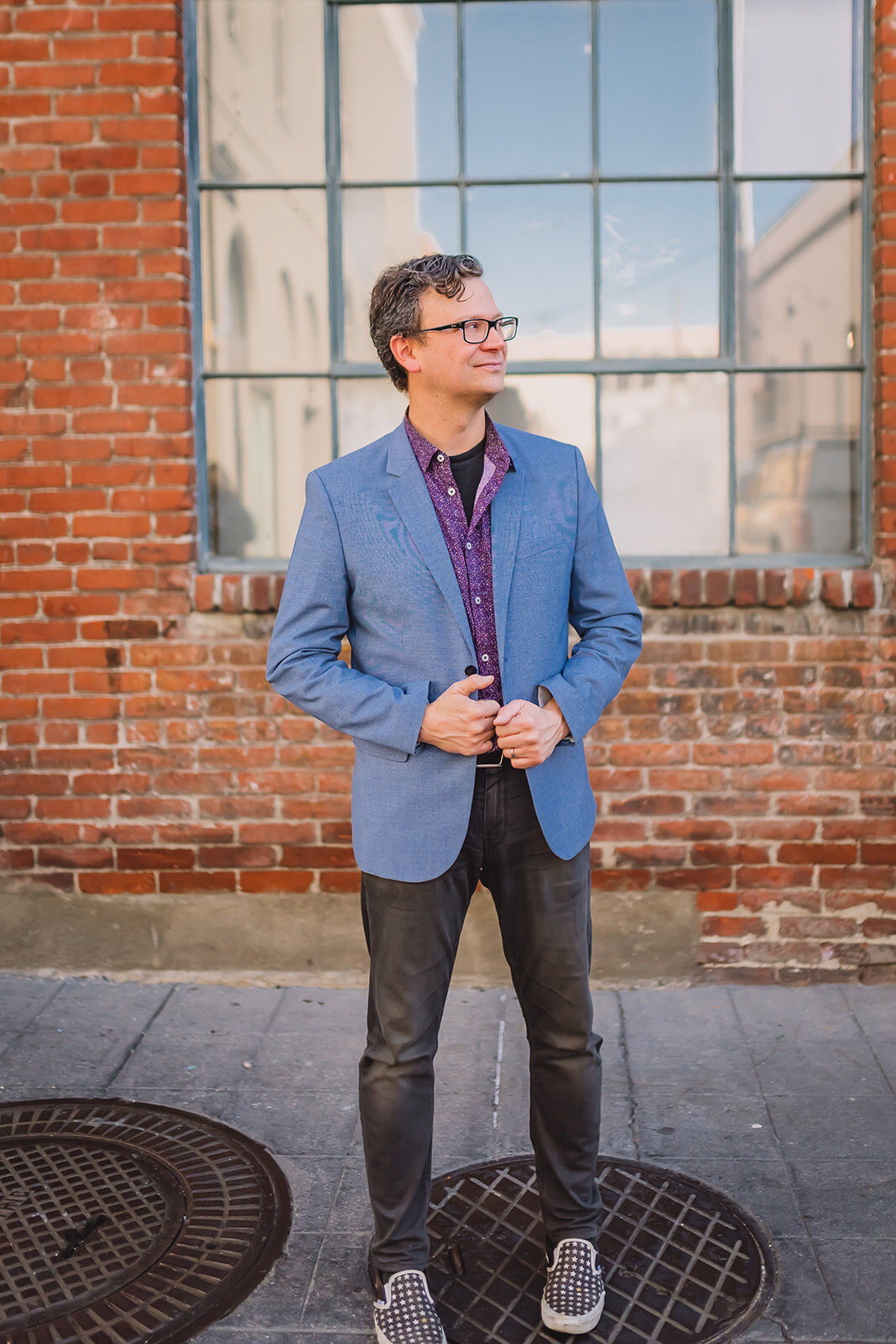 A man in business attire looks off to the side and poses for photographer.