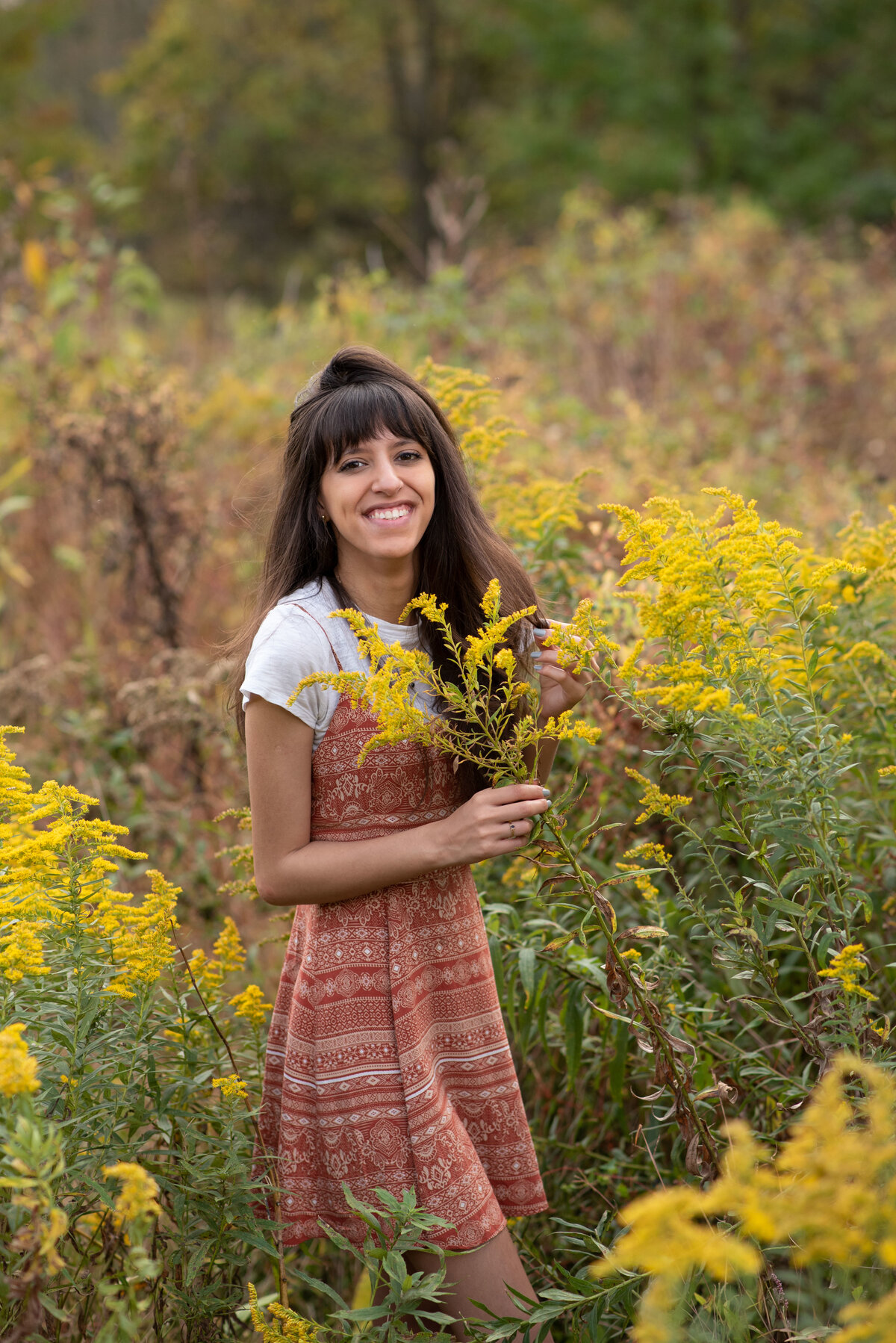 Senior girl in field of golden flowers