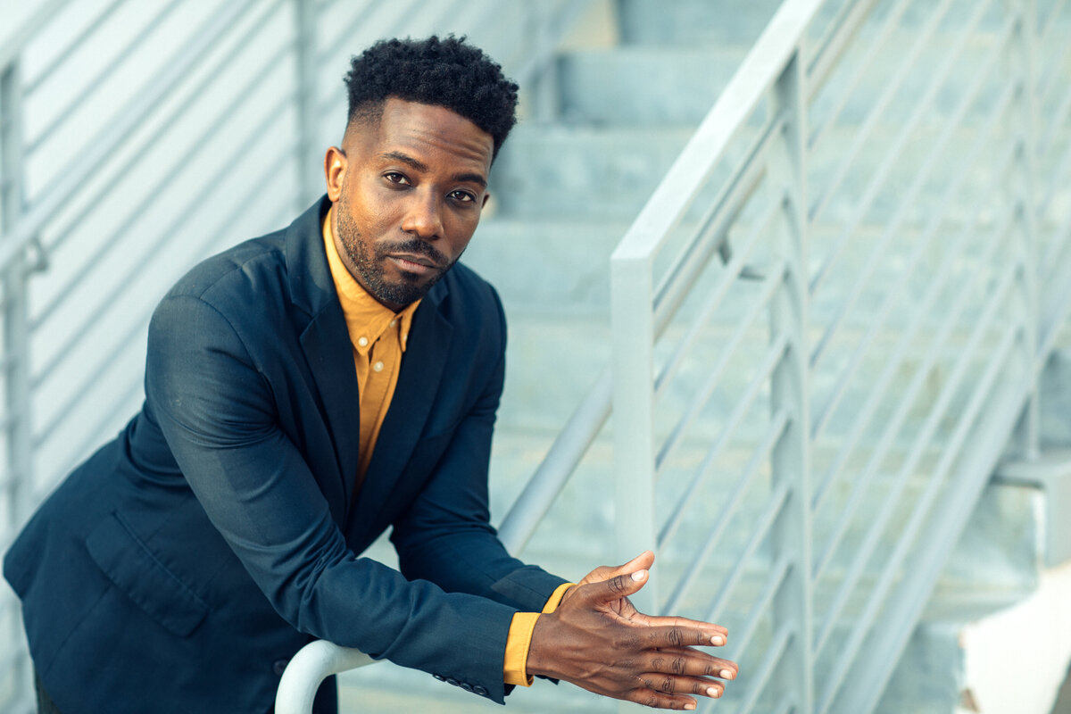 Portrait Photo Of Young Black Man In Blur Coat Leaning On Railings Los Angeles