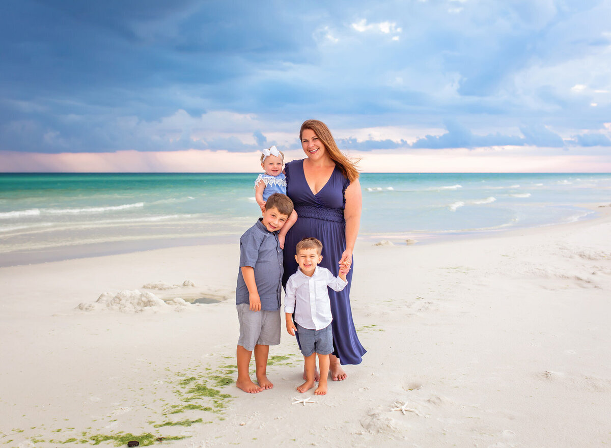 mom-with-three-young-children-by-water-in-destin