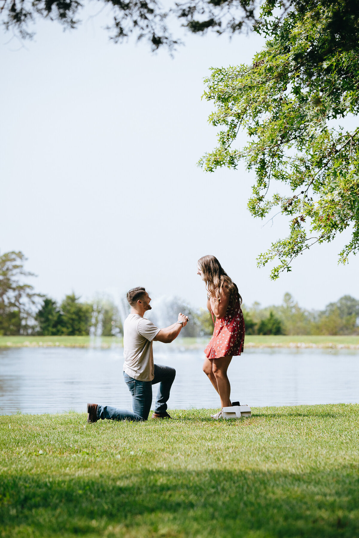 man proposing to girlfriend by a lake