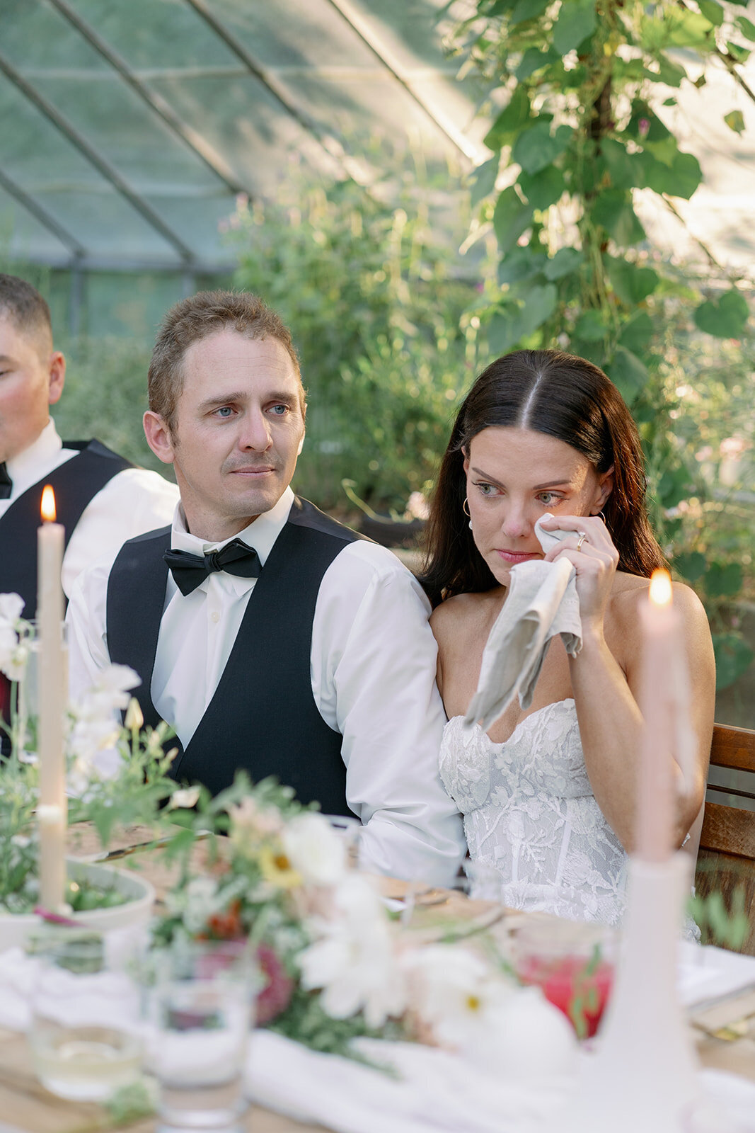 Bride wipes tears during emotional wedding toast at their intimate Glasshouse Community reception in Michigan.