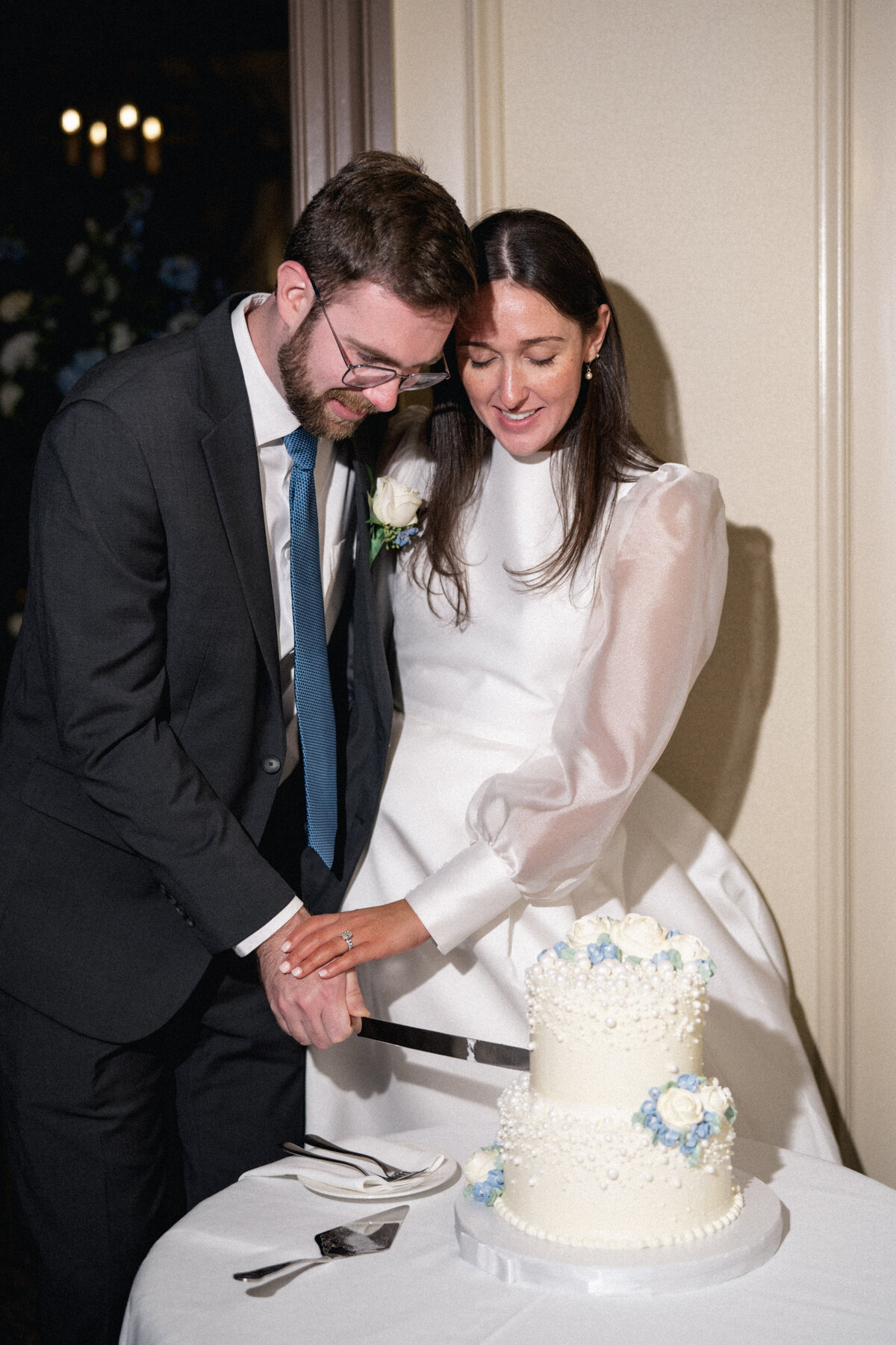 Bride and groom cutting wedding cake during late fall intimate Cleveland wedding.