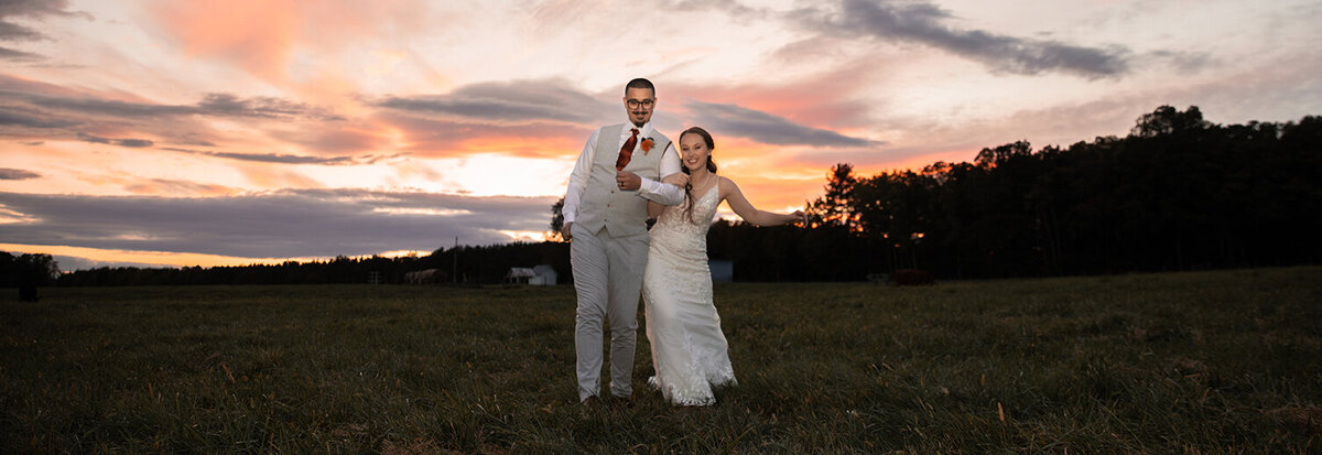 Bride and groom pose for a wedding photo at sunset