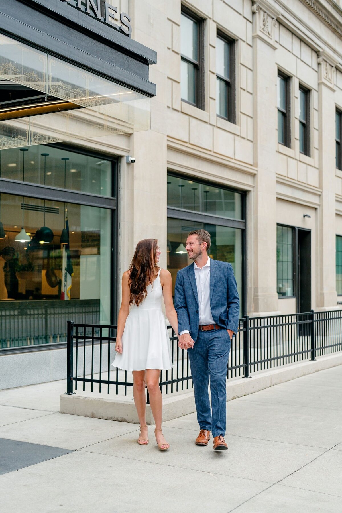 couple-walking-hand-in-hand-downtown-street