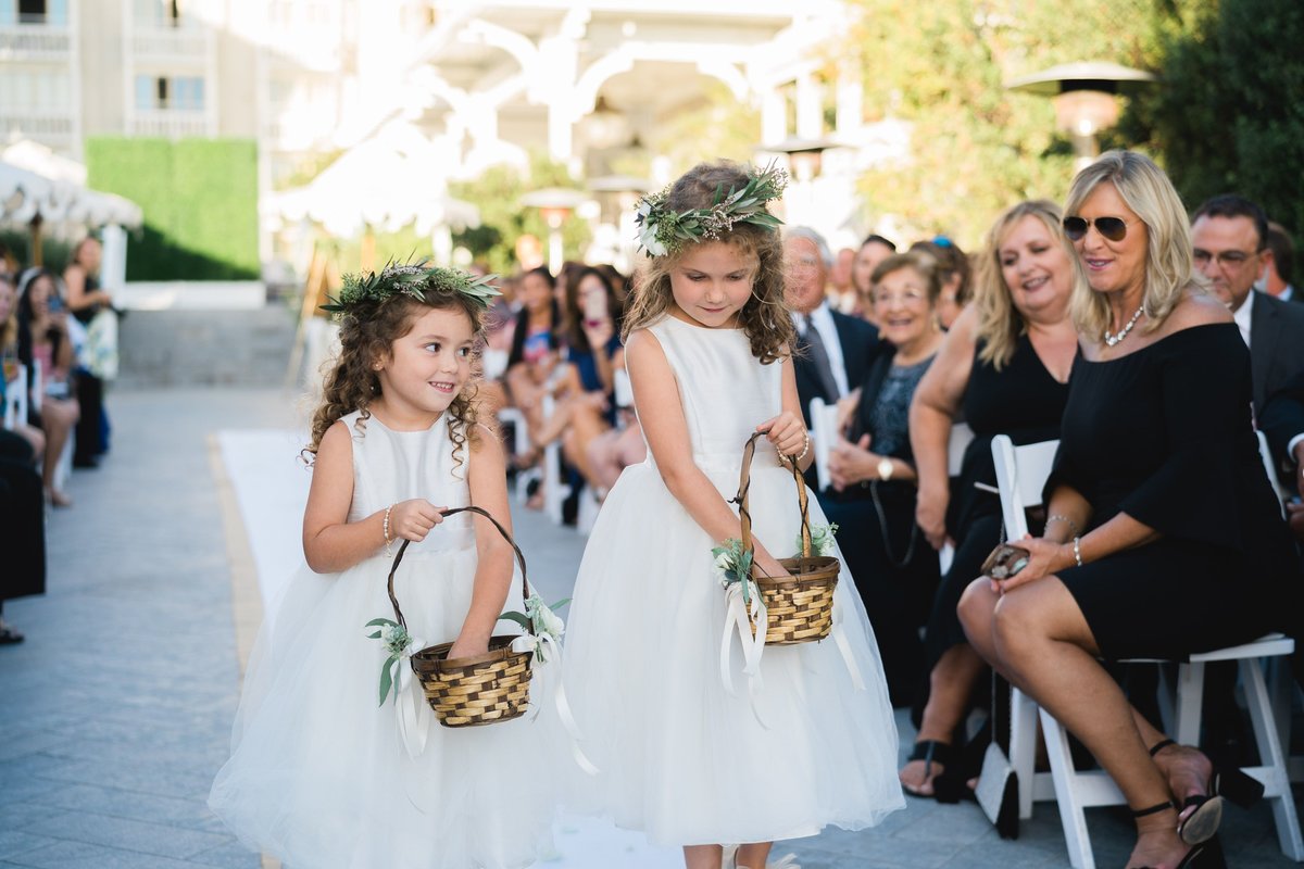 flower girls walking down the aisle with baskets
