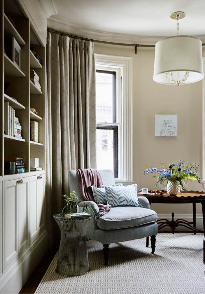 Custom cabinets, beige walls, matching drapery, and a soft blue chair pair with a vintage table and Platner side table in this classic bedroom. As seen in Boston Home Magazine.