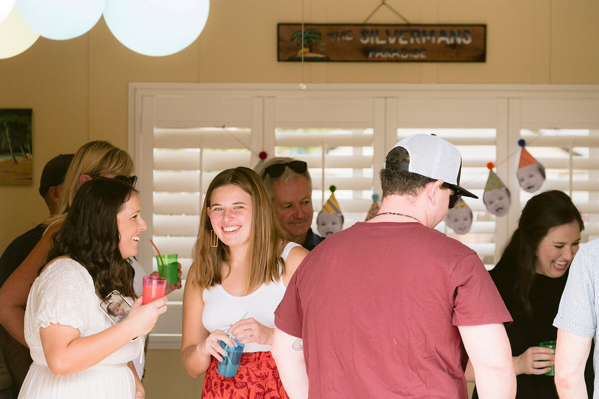 Guests smiling and enjoying a first birthday party celebration in a Bay Area backyard.