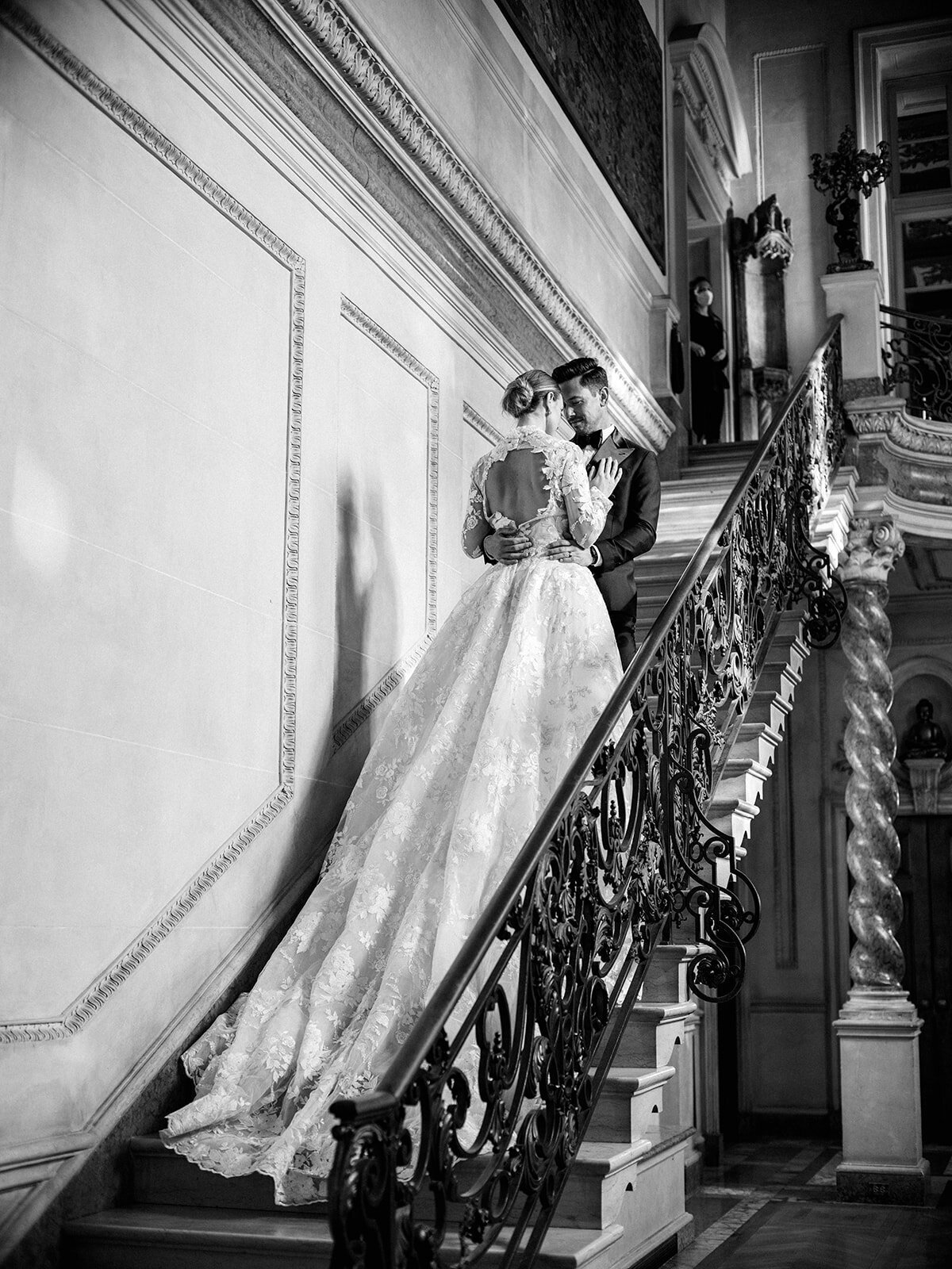 A black and white photo of bride and groom walking up the steps