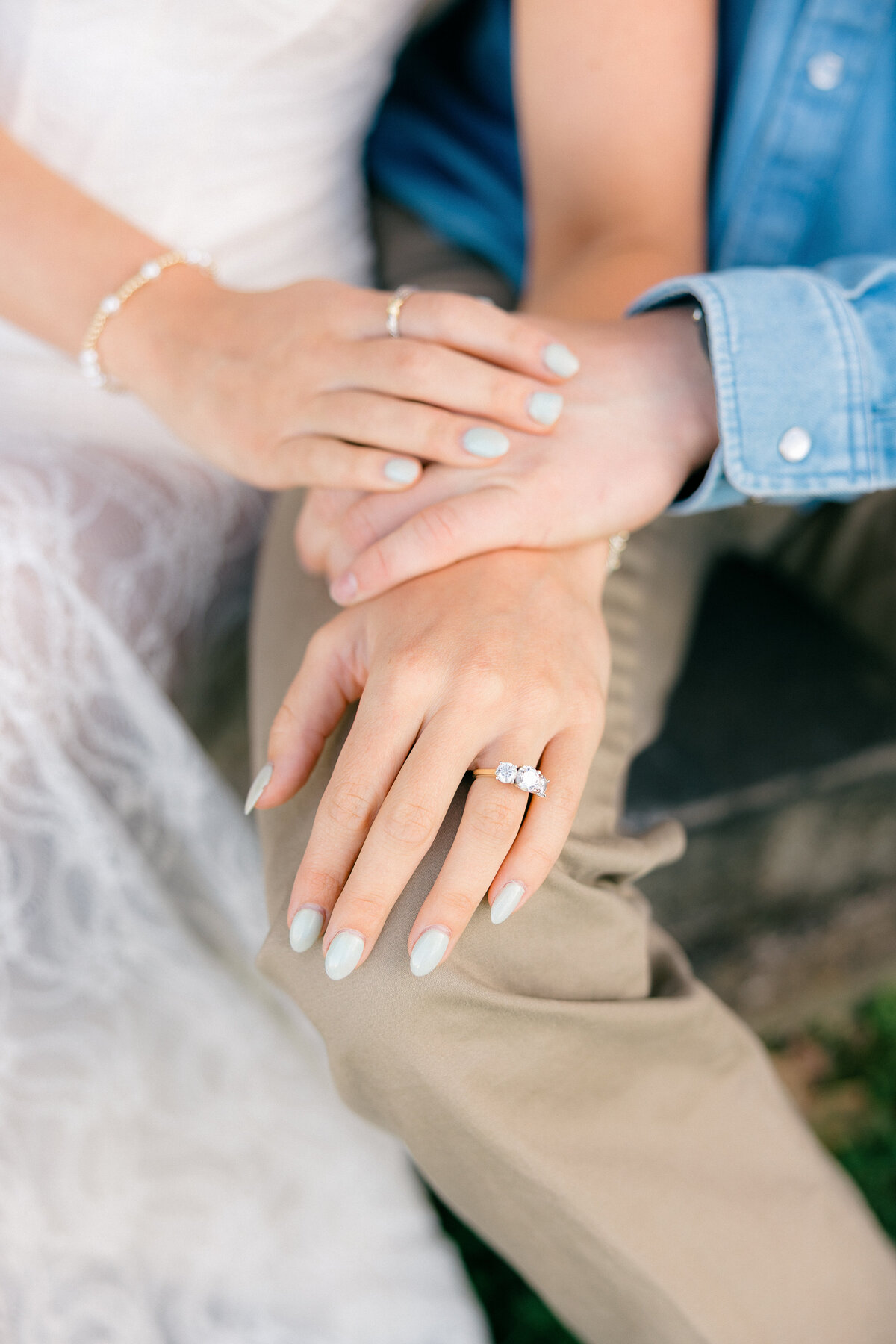 Three-Stone Engagement Ring Close-Up on Intertwined Hands – Northwest Arkansas Engagement Photographer