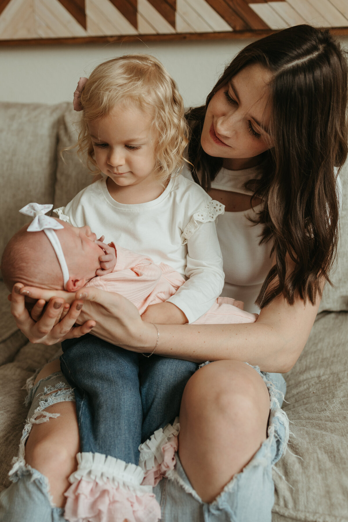 Mom with two daughters during in home newborn session in Longmont, Colorado.
