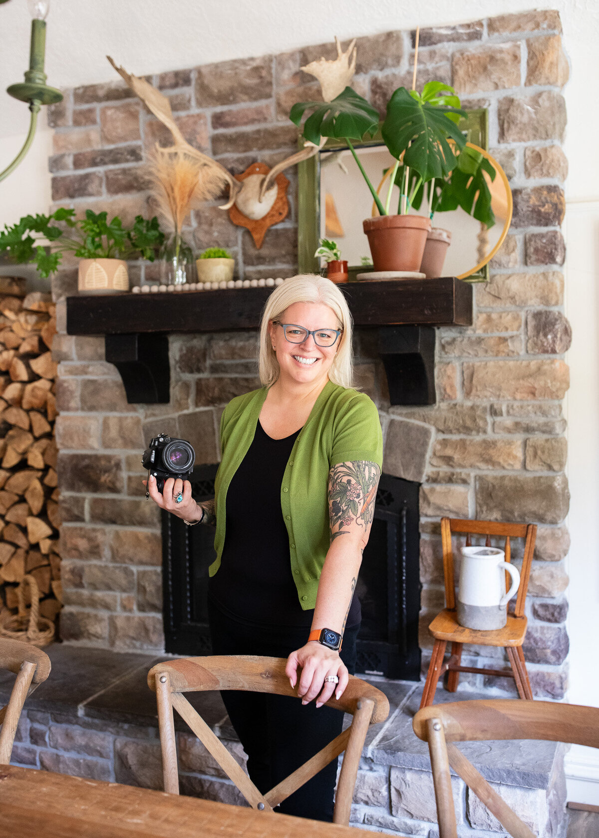 Chef and photographer holds her camera while smiling at the camera