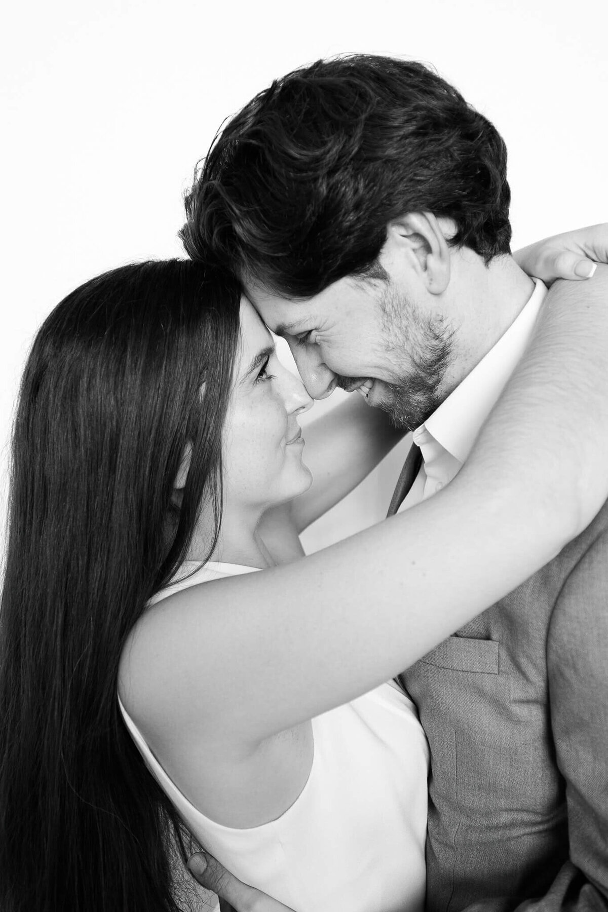 A couple sharing an intimate moment with their foreheads touching in a timeless black and white portrait captured by Monochrome Portraits, a Phoenix photo booth experience.