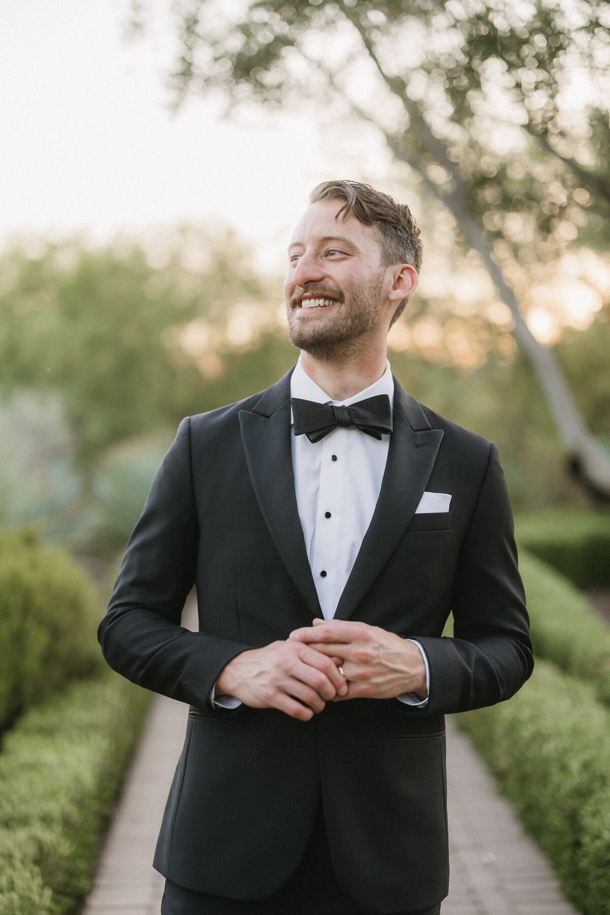 Groom smiling and looking away while walking at El Chorro
