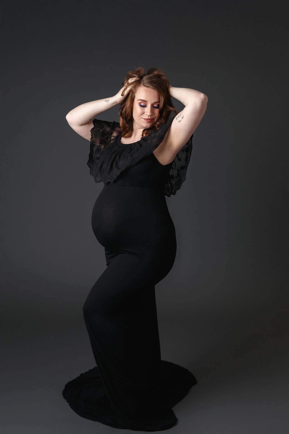 Full lenth portrait of a  pregnant woman wearing a black dress