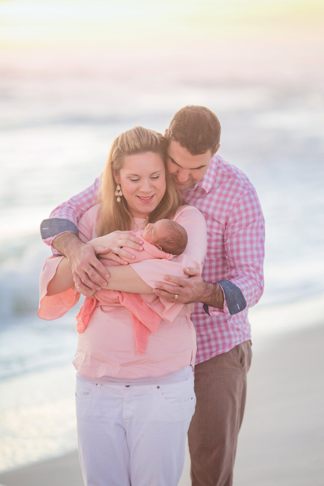 mom-dad-holding-newborn-baby-on-navarre-beach