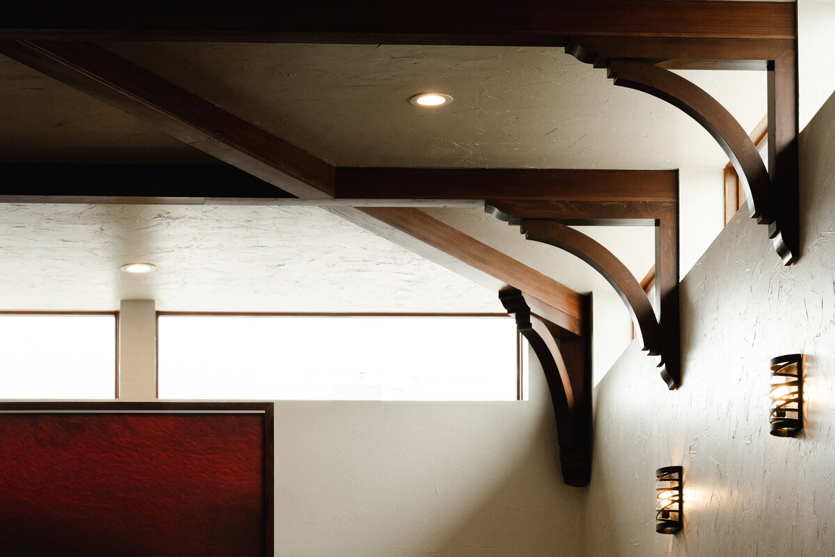 dark wooden corbels next to clerestory windows and wall sconces